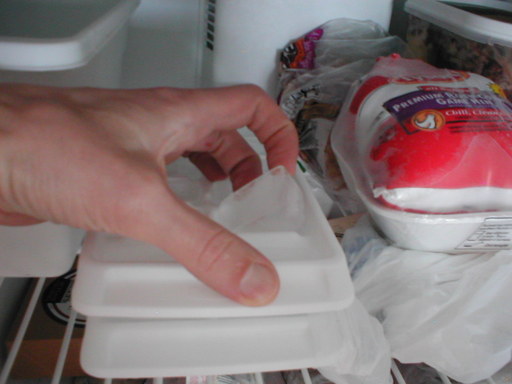 a hand picking an individual ice cube out of the tray